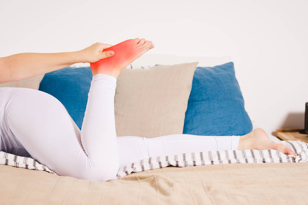 Woman's leg hurts, pain in the heel, massage of female feet at home - Foto, Bild