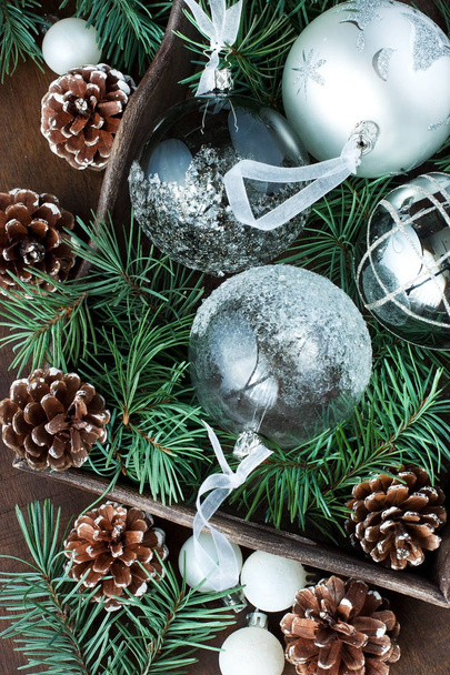 Collection colorée de boules de Noël en plateau en bois, branches de sapin avec cônes de pin sur fond en bois - Photo, image
