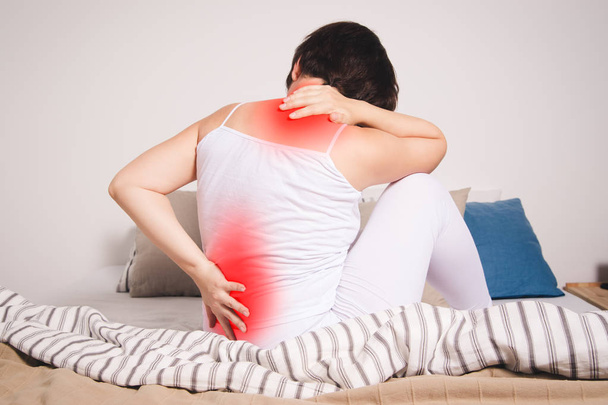 Back pain, kidney inflammation, woman suffering from backache at home, painful area highlighted in red - Φωτογραφία, εικόνα