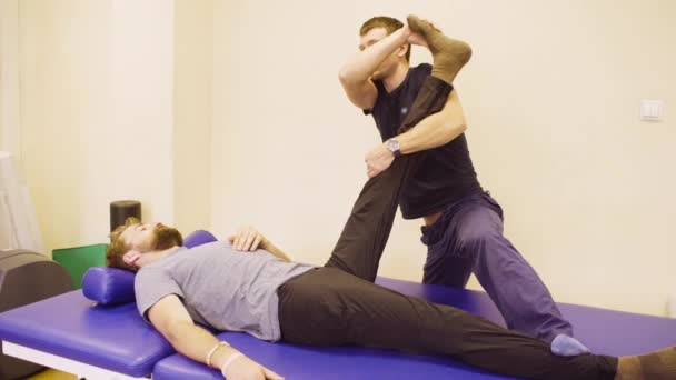 Médico fazendo exercícios de alongamento para incapacitar o homem
 - Filmagem, Vídeo