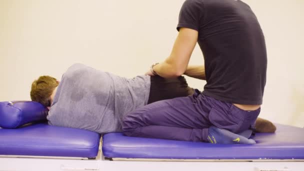 Médico fazendo exercícios de alongamento para incapacitar o homem
 - Filmagem, Vídeo