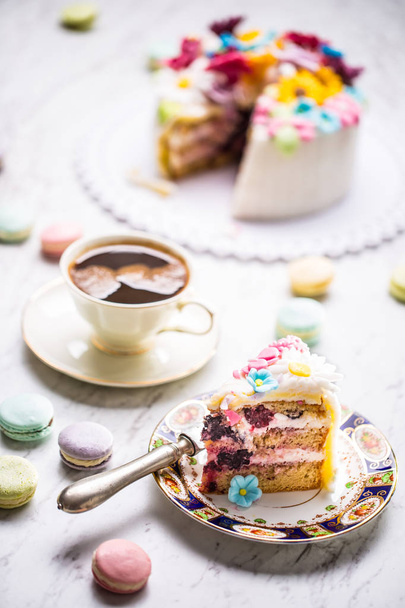 Cake from marzipan flowers macaroons and a cup of black coffee. - Foto, Bild