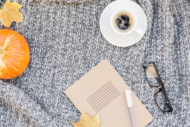 Creative autumn flat lay overhead top view stylish home workspace with notebook coffee cup cozy gray knitted plaid background copy space. Fall season template for feminine blog social media - Foto, imagen
