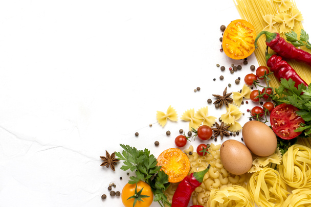 Italian pasta of various kinds with spices, red hot pepper, chicken eggs on a white background. Flat lay, top view. - 写真・画像