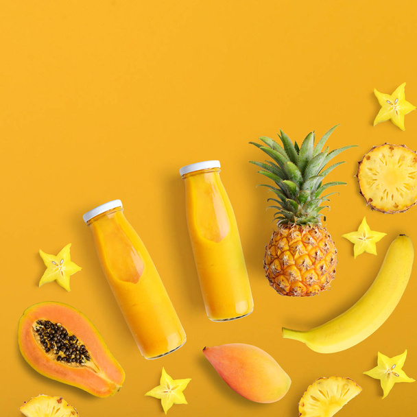 Smothies in bottles with fresh fruits on yellow background, top view - Fotó, kép