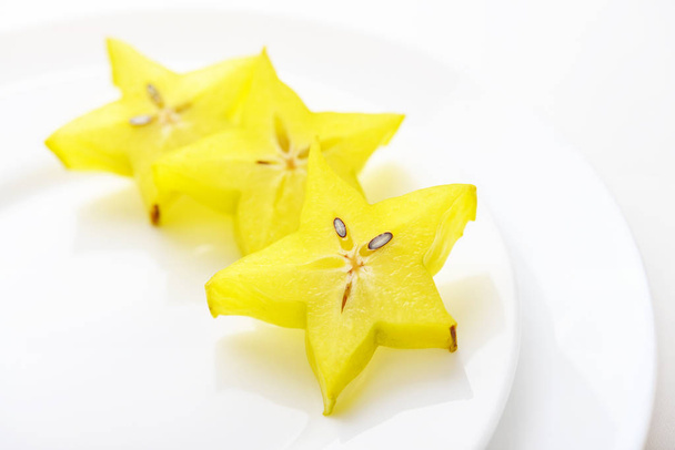 Carambola fruit (starfruit) slices on plate closeup  - Foto, imagen