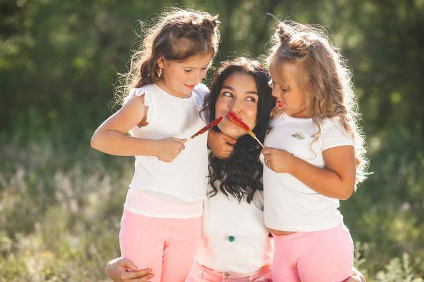 Молодая красивая мать со своими маленькими симпатичными дочерьми
 - Фото, изображение