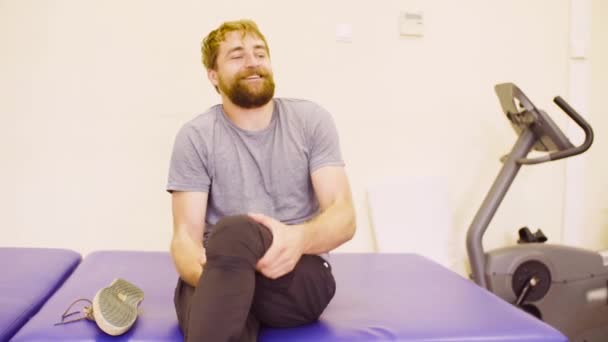 junger behinderter Mann zieht Schuhe an und lächelt - Filmmaterial, Video