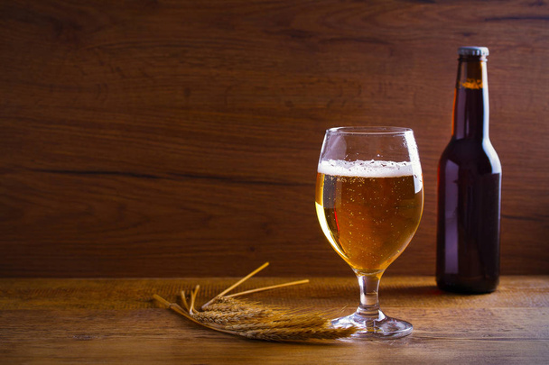 Glass and bottle of beer, ears of barley on wooden background. Ale. horizontal with copy space - Foto, Imagem