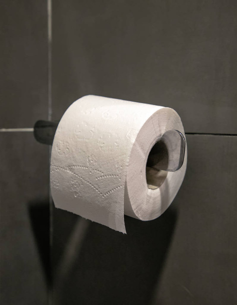 Toiletpapier rol op grijs muur - Foto, afbeelding