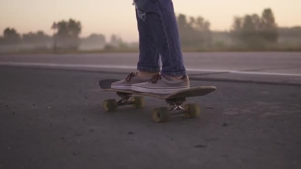 piernas femeninas de cerca. Chica skateboarding al atardecer cámara lenta
. - Imágenes, Vídeo