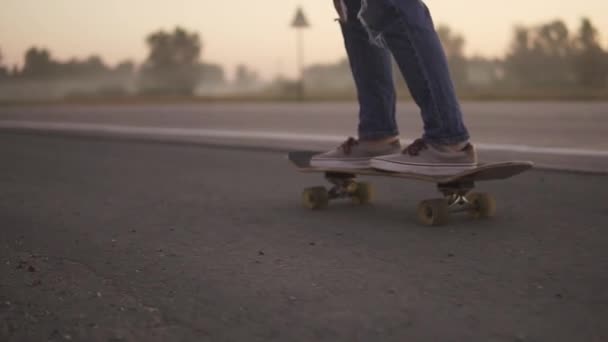 女性の足のクローズ アップ。日没のスローモーションでスケート ボードの女の子. - 映像、動画
