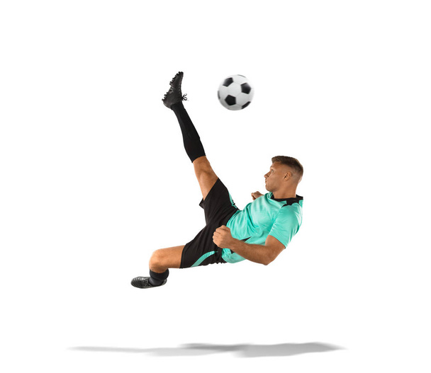 ποδοσφαιριστής που κλωτσάει την μπάλα στον αέρα απομονωθεί σε λευκό - Φωτογραφία, εικόνα