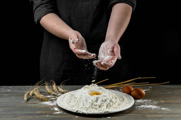 Chef hands cooking dough over wooden background. Food concept - Foto, afbeelding