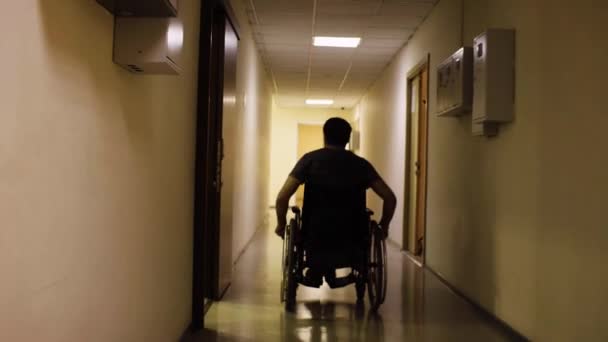 Sziluettjét fogyatékkal élő ember egy tolószékben, a rehabilitációs központ - Felvétel, videó