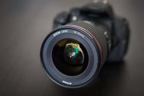 Digital camera or DSLR with camera lens with lense reflections. Photo Camera or Video lens close-up on black background DSLR objective - Foto, Imagem