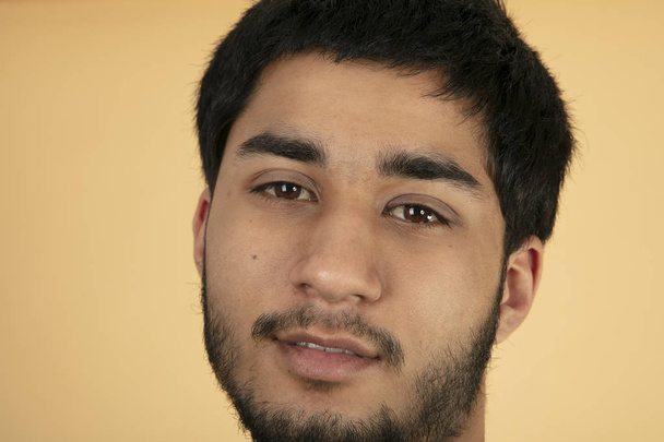 Amichevole giovane uomo su sfondo beige - Foto, immagini
