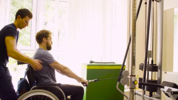 Behinderter Mann im Rollstuhl macht Handübungen - Filmmaterial, Video