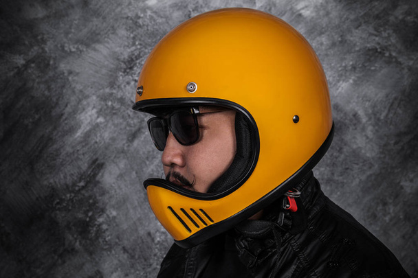 close up of biker man in motorcycle helmet and black leather jacket  - Foto, imagen