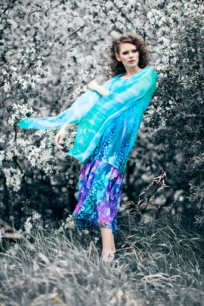 blossom elma ağaçları, moda arasında mavi elbiseli güzel kadın - Fotoğraf, Görsel