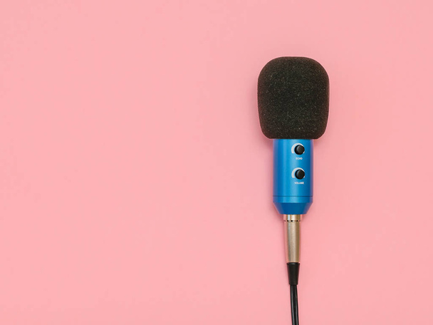 A kék mikrofon a drót, egy rózsaszín háttér. Minimalizmus. A kilátás fentről. A zene-stúdió felszerelés. Lapos feküdt. - Fotó, kép