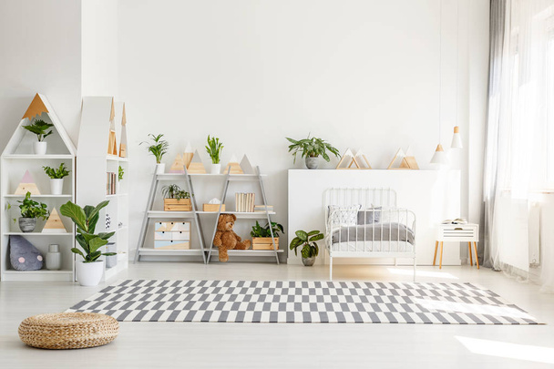 Scandinavian style, wooden furniture with plants and mountain decorations in a sunny, monochromatic child bedroom interior with white walls - Zdjęcie, obraz