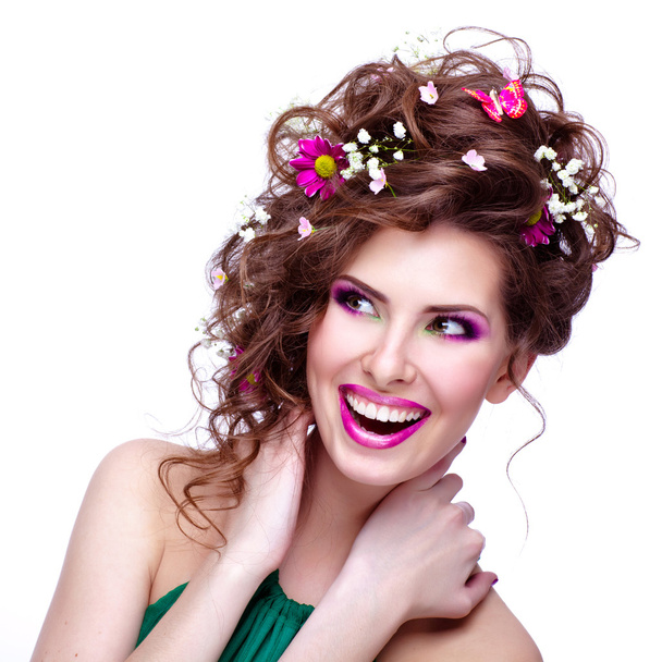 Щаслива молода жінка з квітами у волоссі та яскравим макіяжем ізо
 - Фото, зображення