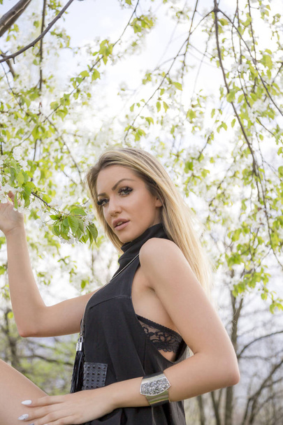 beautiful young woman in stylish clothing posing in pring park - Photo, Image