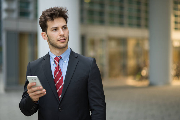 Portrait of businessman using phone in the city  - Photo, Image