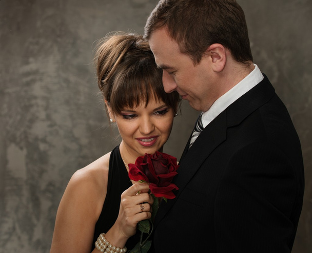 Молодой человек и женщина с красной розой в элегантном вечернем платье
 - Фото, изображение