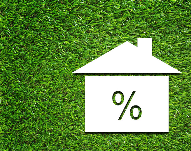 Casa branca e símbolo de taxa de juros no fundo grama verde, conceito financeiro de negócios
 - Foto, Imagem
