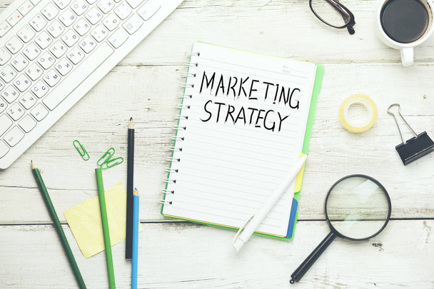 marketing strategy text on notebook with computer keyboard and  stationary - Фото, изображение
