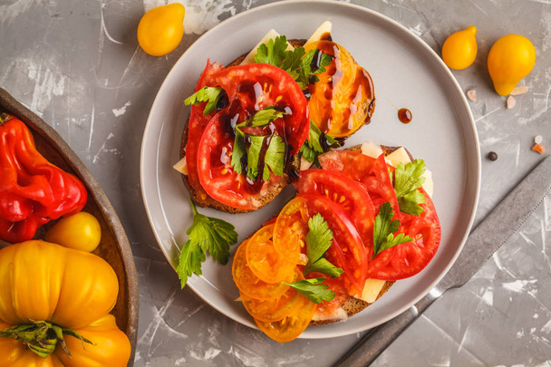 Sandwiches with tomatoes and cheese on gray plate, top view. Clean eating concept. - Φωτογραφία, εικόνα