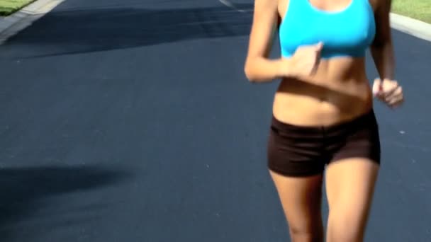 Jovem jogging feminino magro ao longo das estradas suburbanas ao sol
 - Filmagem, Vídeo
