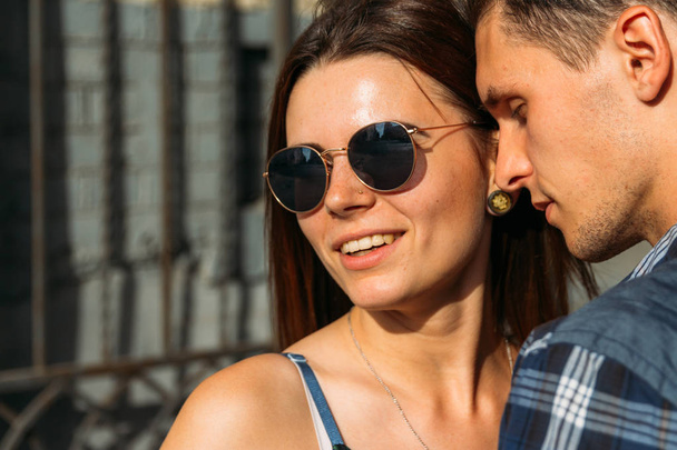 the man with his eyes closed, wants to kiss the girl in sunglasses, close-up. tenderness.the girl smiles and turns away - Фото, изображение