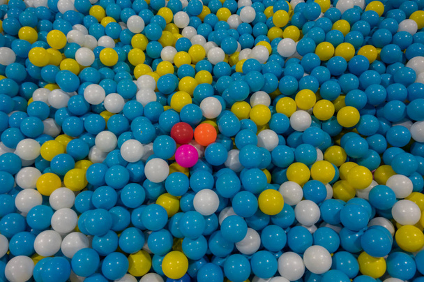 カラフルなプラスチック ボールと背景、赤と黄色の中間の青。写真の選択は、競争を作成したデザインのアイデア、オフィス... それは子供のためのおもちゃも - 写真・画像