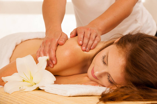 Body care. Spa body massage treatment. Woman having massage in the spa salon - Foto, Imagen