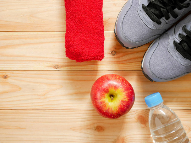 Exercício e equipamento de fitness com maçã vermelha sobre fundo de madeira no ginásio com espaço de cópia. Vista superior. Conceito de bem-estar
 - Foto, Imagem
