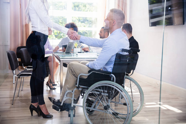 Disabled Happy Businessman Shaking Hand With His Female Colleague In Office - Zdjęcie, obraz