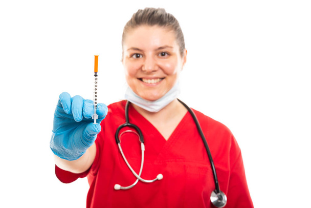 Selective focus of young medical nurse wearing red scrub showing diabetes shot isolated on white background with copyspace advertising area - Zdjęcie, obraz