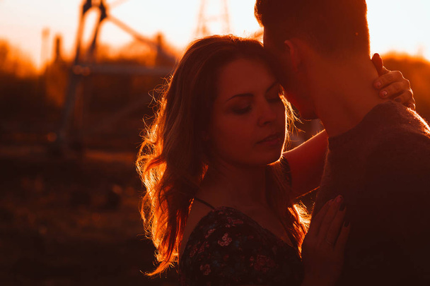 Τύπος και το κορίτσι στο πεδίο στο φόντο ηλιοβασίλεμα. - Φωτογραφία, εικόνα