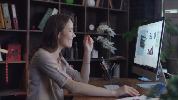 Mujer de negocios exitosa que mira gráficos y diagramas en la pantalla de la computadora
 - Imágenes, Vídeo