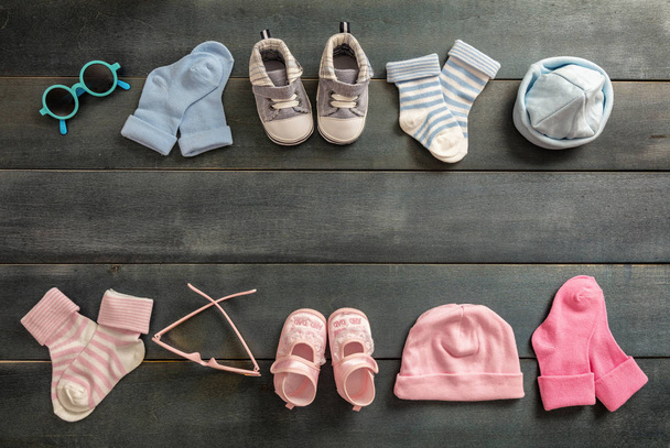 双子の赤ちゃんシャワーのコンセプトです。男の子の赤ちゃんと女の子の靴と靴下青い木製の背景、コピー領域のトップ ビュー - 写真・画像