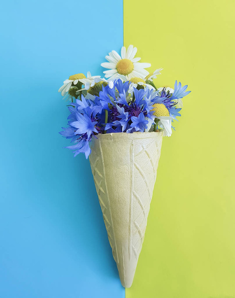 Waffle ice cream chamomile and cornflower on blue background - Foto, Imagem