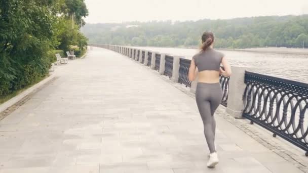 Running woman on city embankment during morning training outdoor - Imágenes, Vídeo
