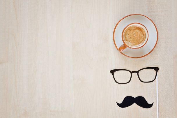 Mustache, glasses and cup of coffee on wooden background. Happy Father's day background. Copy space for inscription. Greeting card - Foto, afbeelding