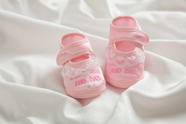 赤ちゃん女の子の靴、白のサテン、シャワーの招待コンセプト コピー スペース - 写真・画像