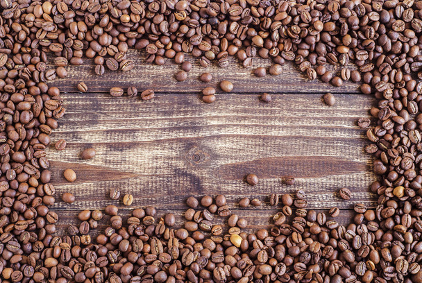 granos de café esparcidos sobre un fondo de madera 2
 - Foto, imagen