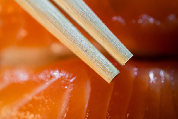 Eldobható bambusz-pálcika és a lazac sushi háttér makró lövés - Fotó, kép