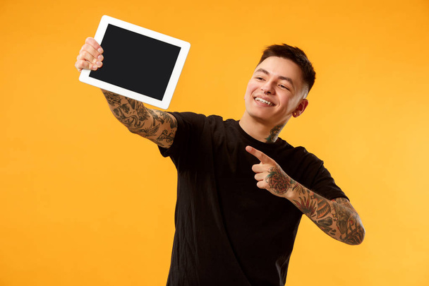 Portrait of a confident casual man showing blank screen of laptop - Foto, imagen